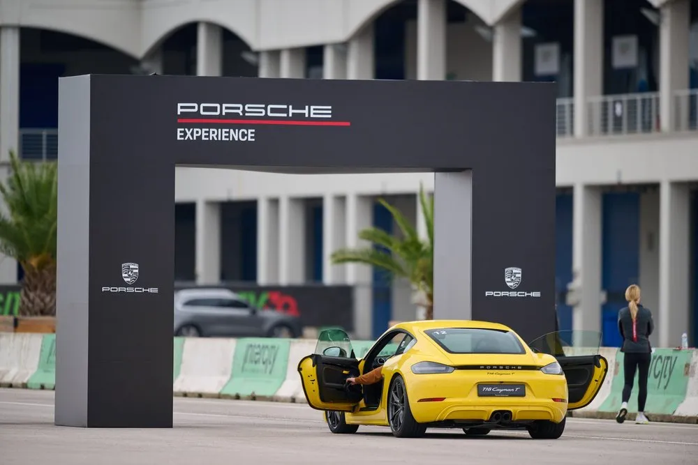 A yellow Porsche under the Porsche Experience arch at the GSA alumni day